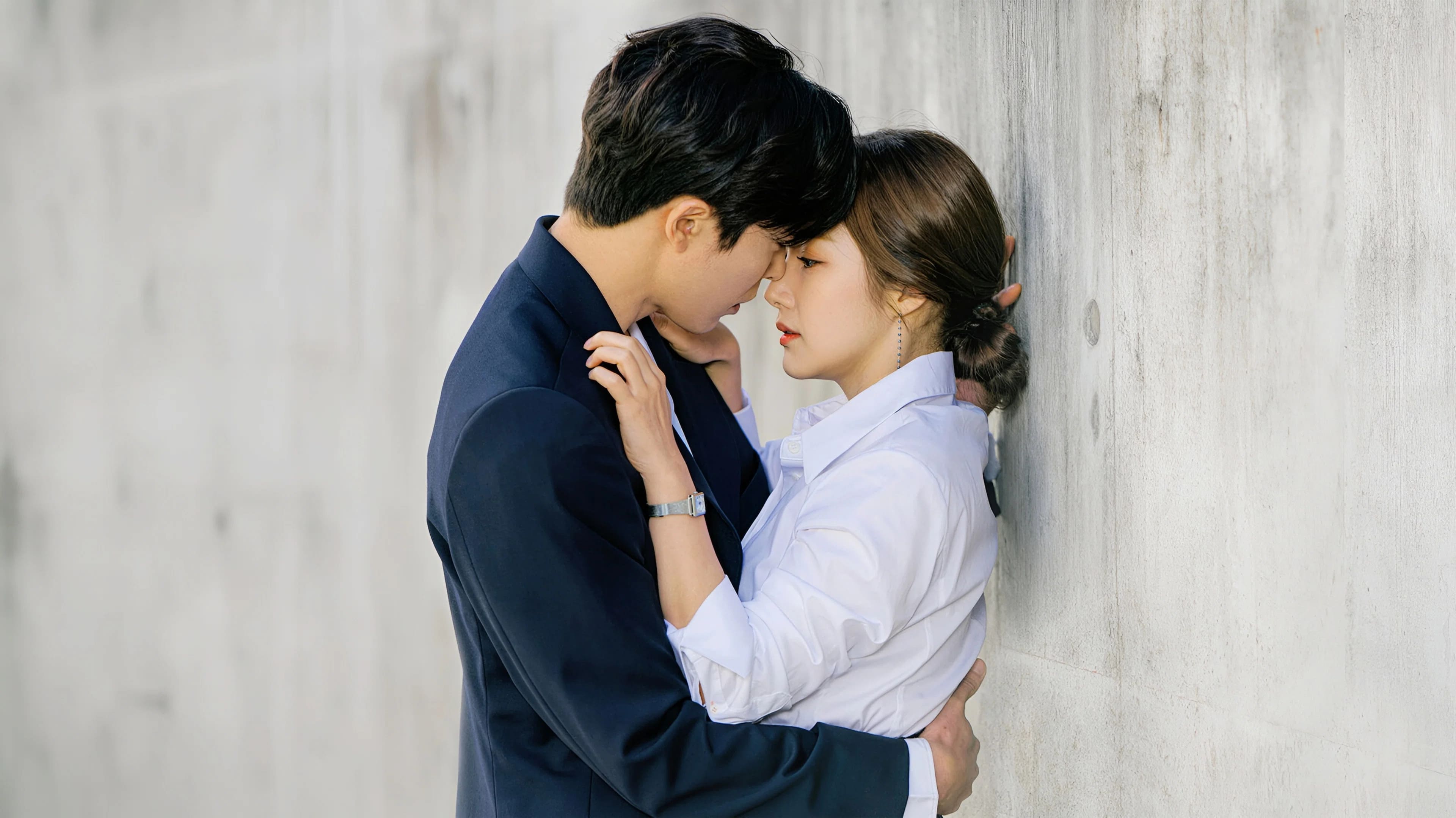 Ryan Gold and Sung Deok-mi stand close against a wall, looking at each other as they nearly kiss.